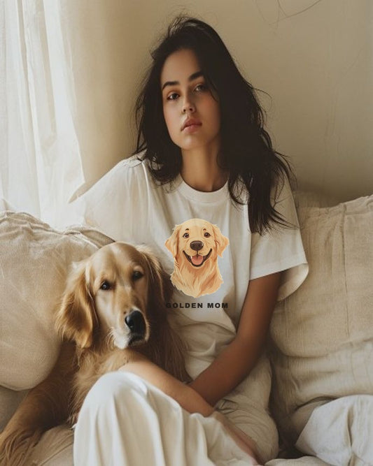 Woman wearing the Golden Retriever Mom illustrated tee on a linen sofa with her golden retriever