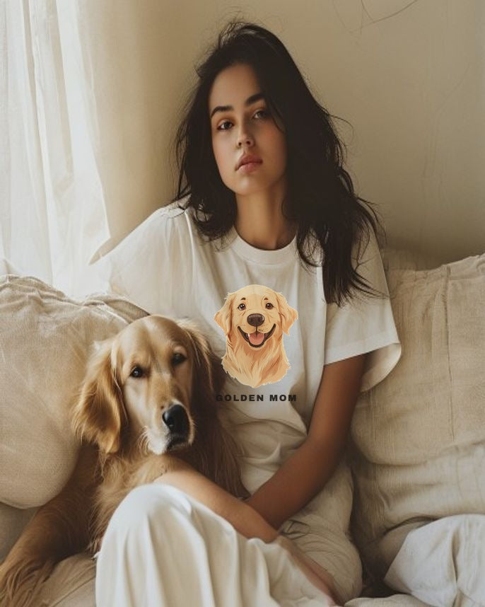Woman wearing the Golden Retriever Mom illustrated tee on a linen sofa with her golden retriever